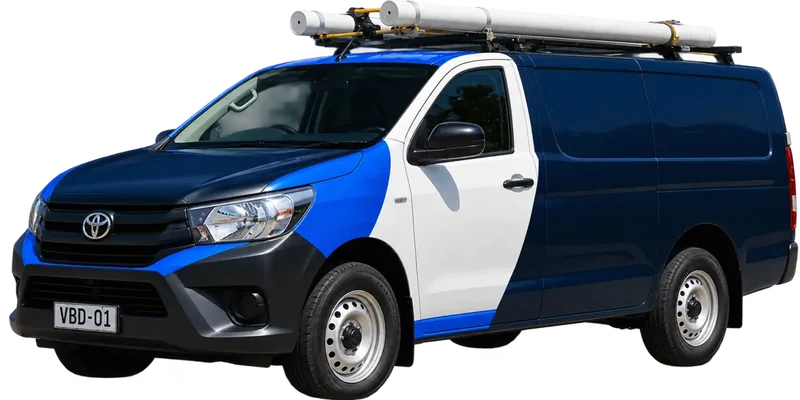 A licensed Box Hill plumbing van loaded with pipe on the roof rack